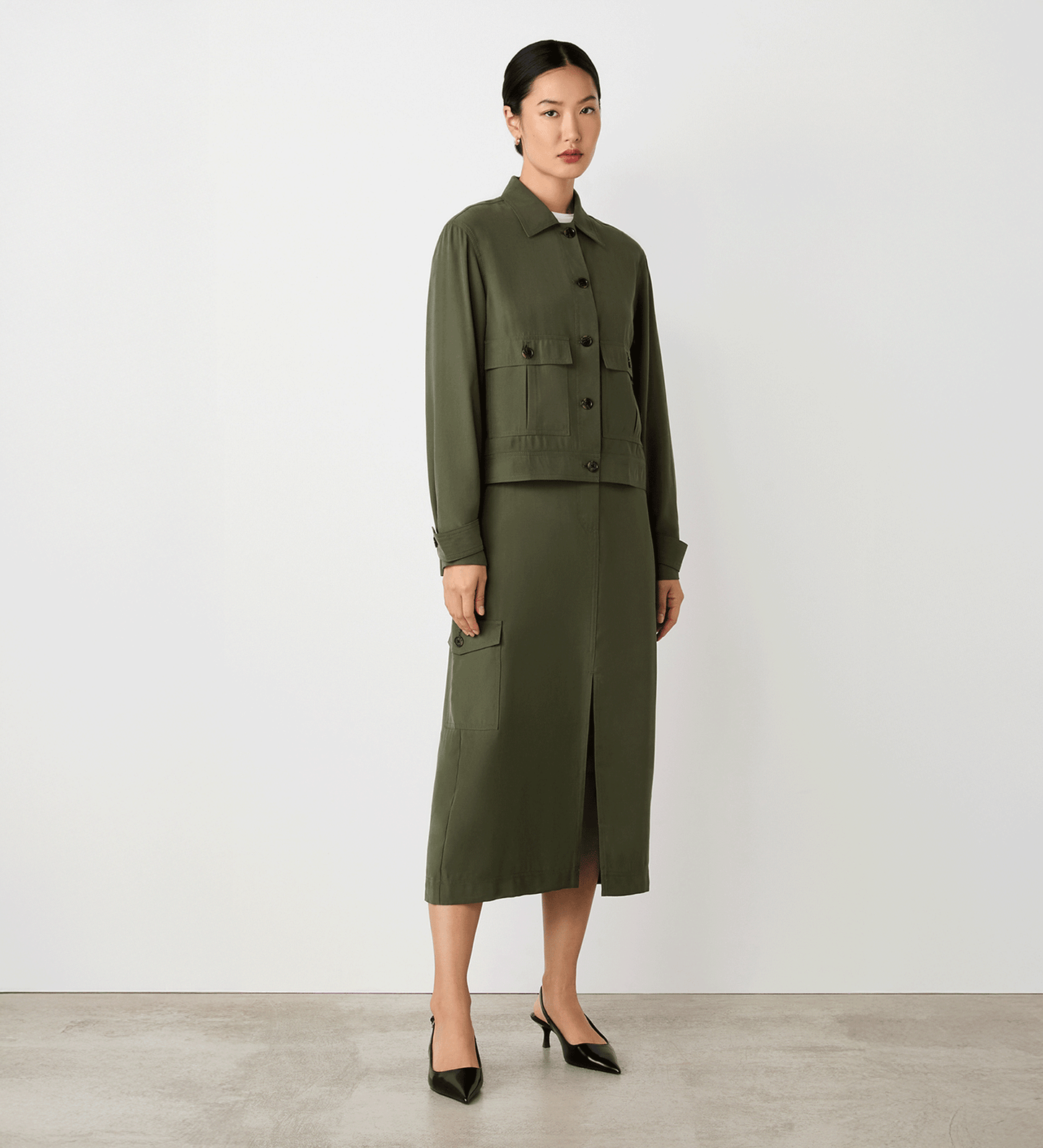 Full body view of a model wearing the Alexa Khaki Utility Jacket buttoned up facing side-on.