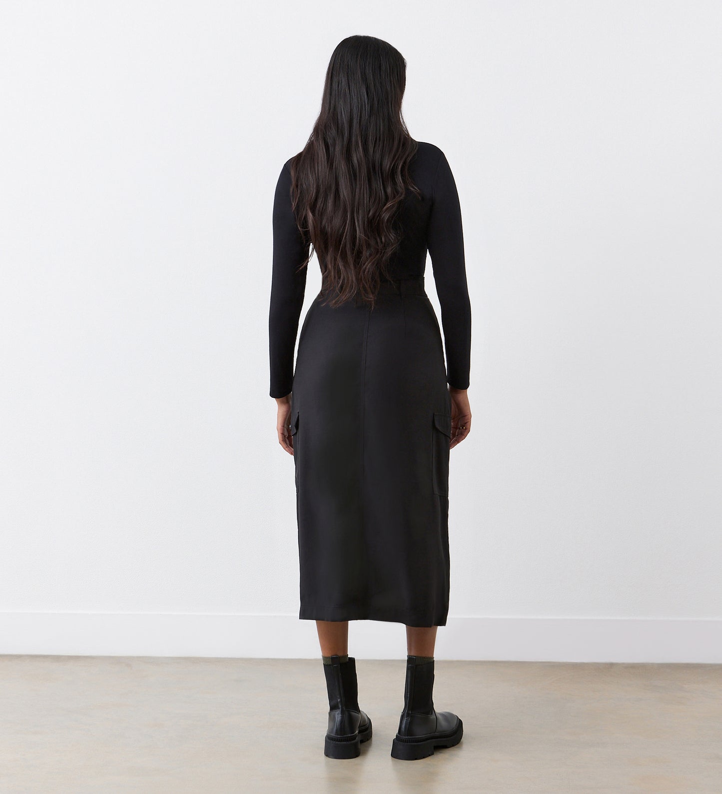 Full body back view of a model wearing the Juliette Black Cargo Skirt facing away from the camera.